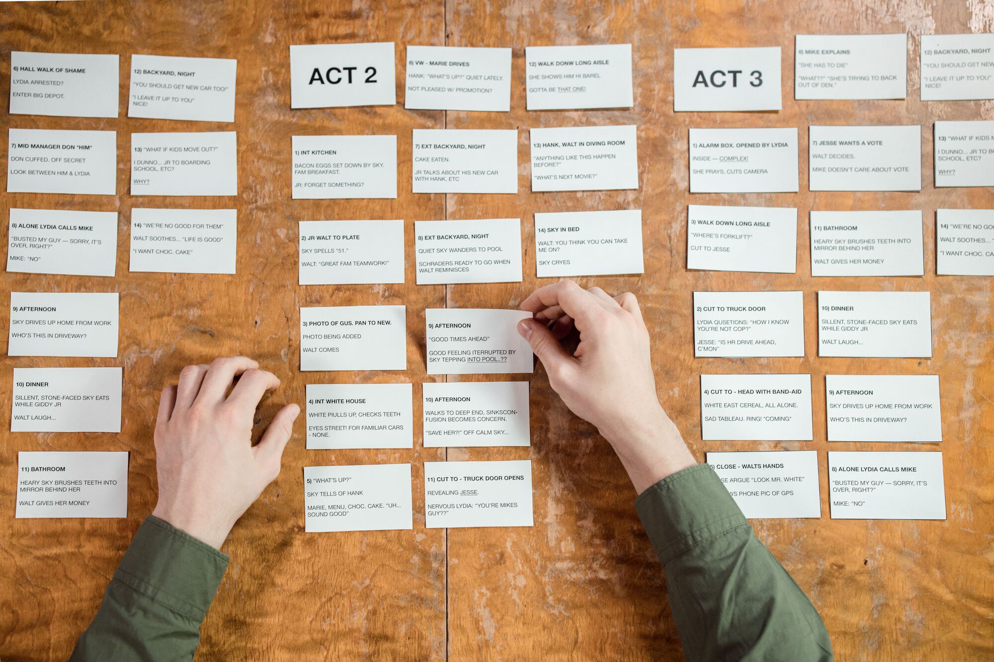 Hands arrange story-structure index cards on a table.