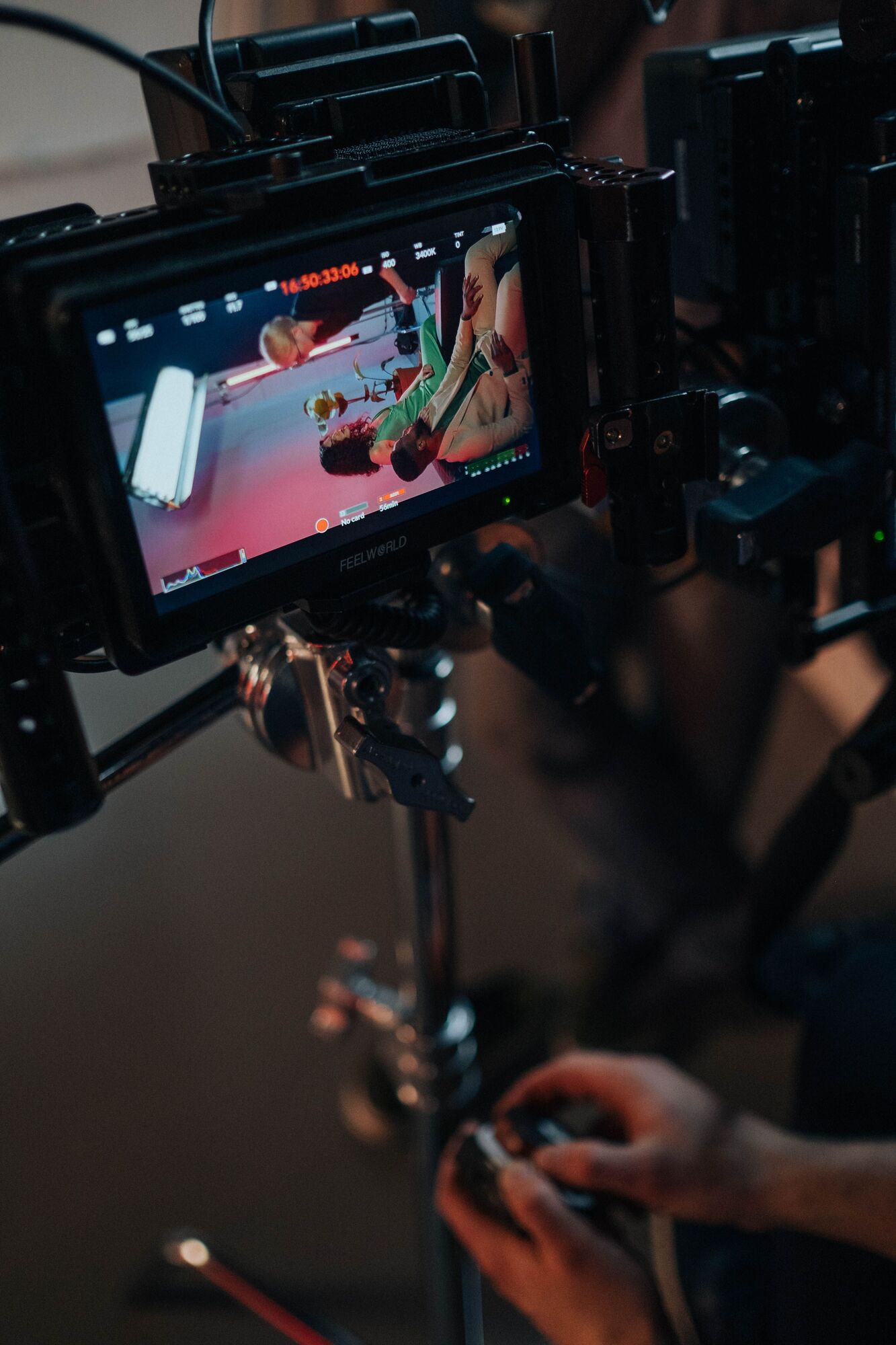 A camera operator's monitor shows the scene being filmed.